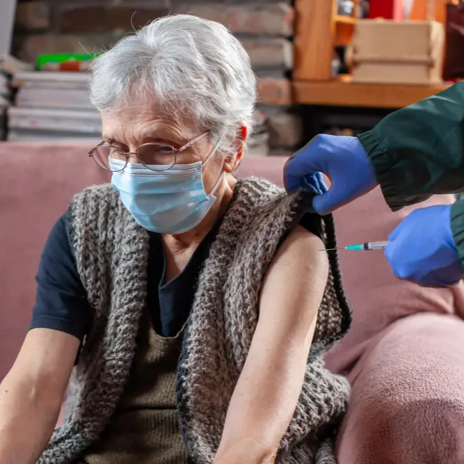 Elderly woman receiving a flu vaccination